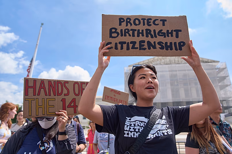 DOSSIER – Hannah Liu, 26 ans, de Washington, brandit une pancarte en faveur du droit de citoyenneté, le 15 mai 2025, devant la Cour suprême de Washington