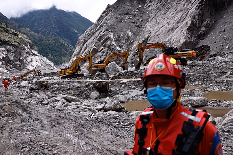 Un secouriste se tient près des excavatrices dans la principale zone touchée par la catastrophe, au port de Gyirong, dans la région autonome du Tibet, le 6 septembre 2026.