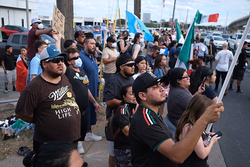 Des personnes manifestent sur le site où les autorités locales affirment qu'un agent de l'ICE a blessé par balle un homme à Austin, le 20 septembre 2026.