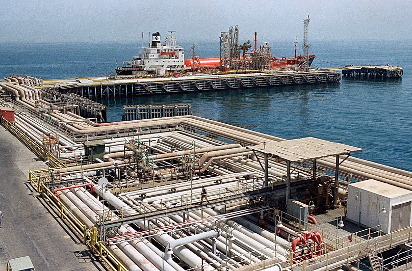 Des oléoducs serpentent dans la zone portuaire des installations d'Aramco à Ras Tannura, en Arabie Saoudite, le 25 septembre 1990, alors qu'un navire panaméen est amarré au quai.