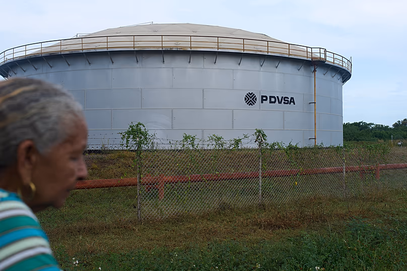 Une femme marche près d'un réservoir de stockage de pétrole de la compagnie pétrolière publique vénézuélienne PDVSA à Cabimas, Venezuela, le mardi 1er septembre 2026.