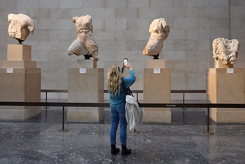 DOSSIER : Un visiteur prend des photos de sculptures faisant partie des marbres du Parthénon au British Museum de Londres,