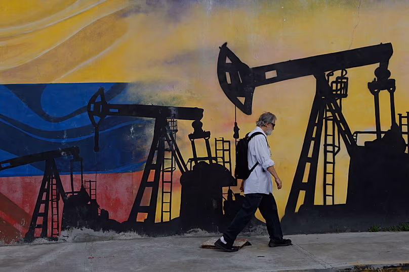 DÉPOSER. Un piéton passe devant une fresque murale représentant des puits de pétrole à Caracas, Venezuela, le 29 août 2026.