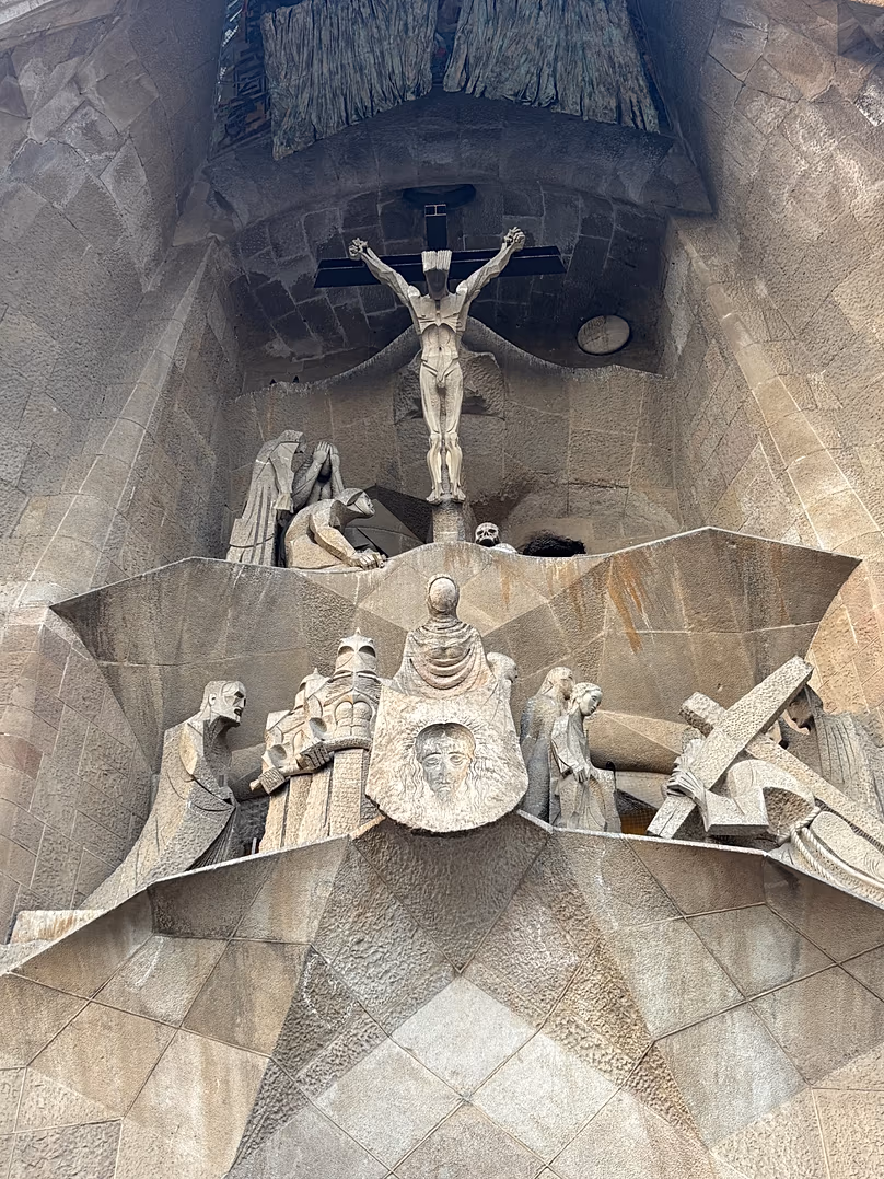 Façade arrière de la Sagrada Familia montrant un Christ crucifié. En bas à gauche, une image de Gaudí et d'un soldat qui a inspiré « Star Wars ».