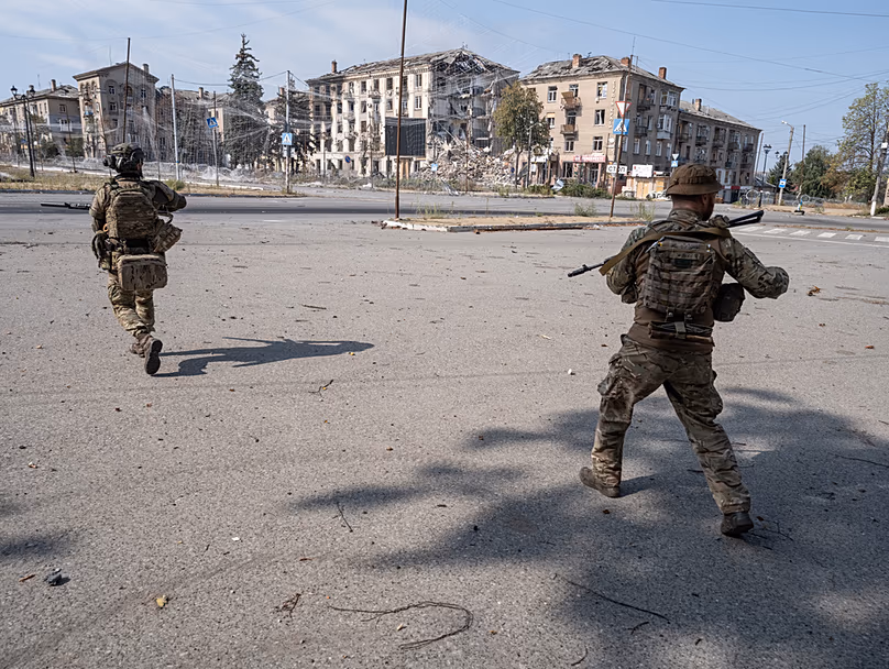 Des militaires ukrainiens courent dans une rue de Druzhkivka ; photo fournie par le service de presse de la 93e brigade mécanisée séparée d'Ukraine