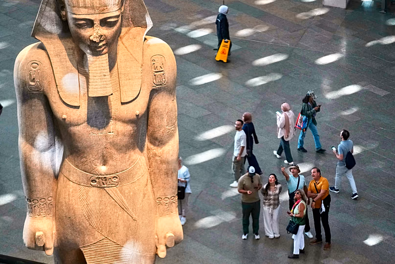 Visiteurs à côté d’une statue de Ramsès II au Grand Musée égyptien de Gizeh, en Égypte, le 4 novembre 2025.