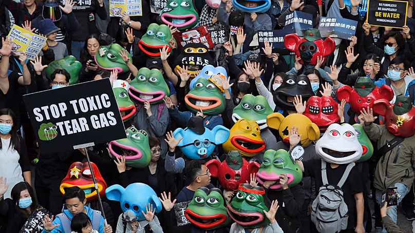 Des manifestants pro-démocratie portent des masques Pepe la grenouille lors d'une marche à Hong Kong