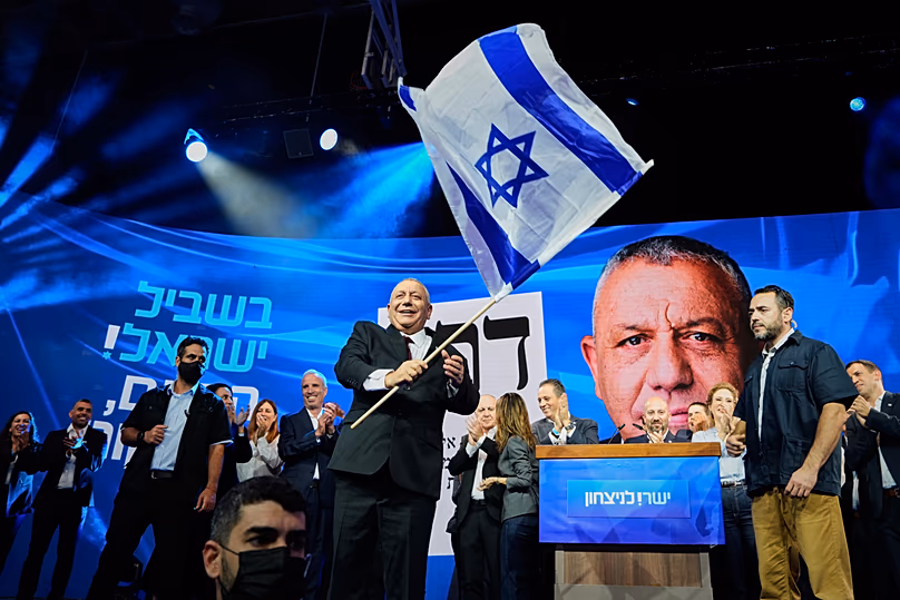 Gadi Eisenkot brandit un drapeau israélien sur scène après la publication des premiers résultats des élections générales israéliennes à Tel Aviv, Israël, le mercredi 28 octobre 2026. 