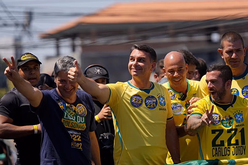 Le candidat de l'opposition à la présidentielle, le sénateur Flavio Bolsonaro, au centre, donne un signe de « pouce levé » à ses partisans lors d'un rassemblement électoral