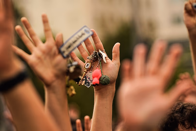 A woman, holding a set of keys in her hand, protests during a housing demonstration.